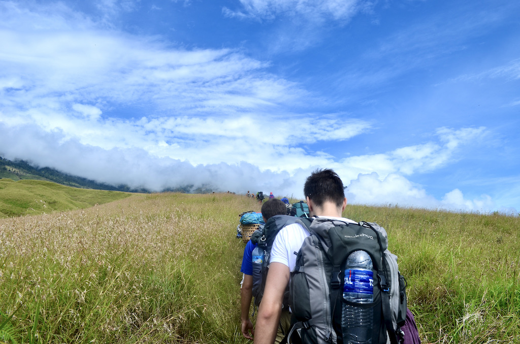 people walking towards mountains